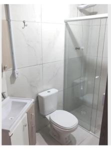 y baño blanco con aseo y ducha. en Casa completa conforto e tranquilidade, en Florianópolis