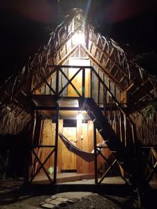 una casa en el árbol con una hamaca por la noche en Cabañas Mangle House, en Buenaventura