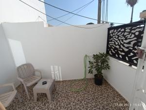 una habitación con una silla y una planta en ella en Fufa Apartment, en Monastir