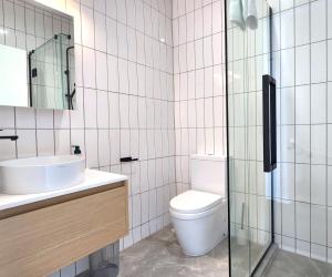 a bathroom with a toilet and a glass shower at U Suites on Trieste Way in Paraparaumu