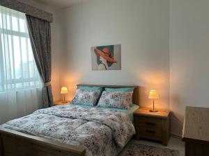 a bedroom with a bed and two night stands with lamps at شقة البحيره in Sharjah