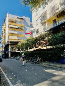uma pessoa andando por uma rua em uma cidade em Jolie Center Apartment em Tirana