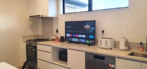 a kitchen with a counter with a tv on it at Cozy 2- Bedrooms Unit In Hamilton in Hamilton