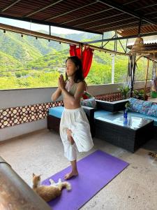 a woman doing yoga with a cat on a rug at Casa Italia Guest House in Taganga