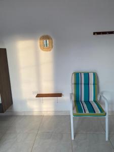 a chair and a table in a room at Casa Guiwa Hostel in Palomino