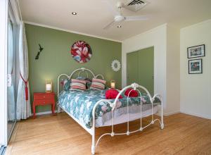 1 dormitorio con cama y pared verde en Waimoana Garden Accommodation, en Whangarei