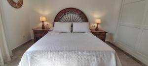 - une chambre avec un grand lit blanc et deux lampes dans l'établissement Casa el Rancho Grande, à Alora