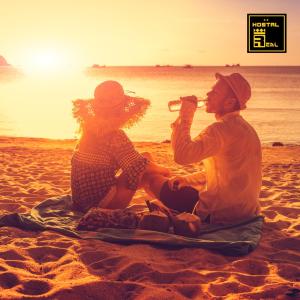 Un uomo e una donna seduti sulla spiaggia di Hostal Real Piura - Oficial a Piura
