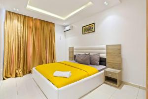 a bedroom with a large bed with a yellow blanket at OlliebeierArtApartment Charming recently refurbished three-bedroom apartment located in VI in Lagos