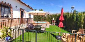 une terrasse avec un parasol, une table et des chaises dans l'établissement Casa el Rancho Grande, à Alora