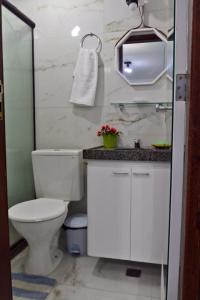 a white bathroom with a toilet and a sink at Charming 1-BR Apartment in Boa Viagem - with Ocean View in Recife