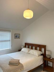 een slaapkamer met een groot bed en een licht bij Little Roper Cottage in Mount Beauty
