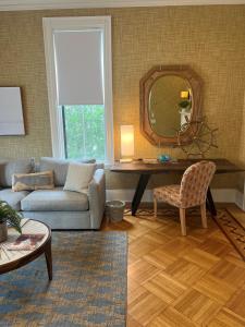 a living room with a couch and a mirror at The Centerboard Nantucket in Nantucket