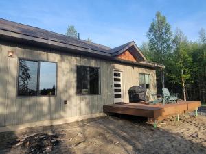 a tiny house with a porch and a deck at Cozy Apartment Between the Rivers in Soldotna
