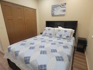 a bedroom with a bed with a blue and white quilt at Cozy Apartment Between the Rivers in Soldotna