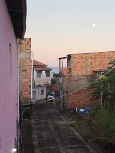 un callejón entre dos edificios de ladrillo con un coche en Casa laranja cabuçu, en Saubara