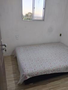 a bed in a room with a window at Casa laranja cabuçu in Saubara