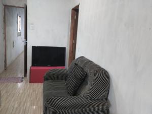 un sofá en una sala de estar con TV en Casa laranja cabuçu, en Saubara