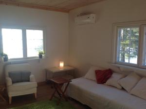 a bedroom with a bed and a chair and windows at Houses by the sea near the city in Lidingö
