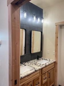 a bathroom with two sinks and two mirrors at Cozy Apartment Between the Rivers in Soldotna