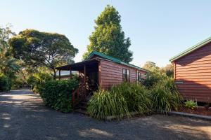 a cabin with a porch next to a house at NRMA South West Rocks Holiday Park in South West Rocks