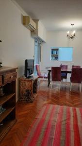 uma sala de estar com uma televisão e uma mesa com cadeiras em Hermoso departamento en Recoleta em Buenos Aires