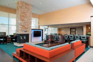 a lobby with an orange couch and a fireplace at Residence Inn by Marriott Austin - University Area in Austin