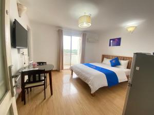 a bedroom with a bed and a table and a television at hotel Gia Phong Phat in Xóm Mỹ Thanh