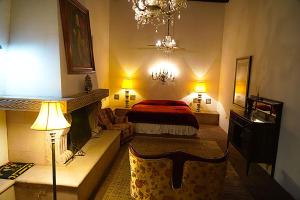 um quarto com uma cama, uma lareira e 2 candeeiros em Hotel la Mansión em Álamos