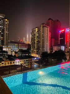 a large swimming pool on top of a city at night at RumaKL at TR Residence Titiwangsa Sentral in Kuala Lumpur