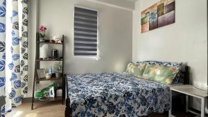 ein kleines Schlafzimmer mit einem Bett und einem Fenster in der Unterkunft Mactan Oasis- Stylish Condo with Pool and Netflix in Agus