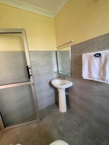 a bathroom with a sink and a toilet and a mirror at SEGA LODGE RESORT in Sega +44 photos