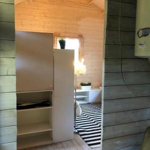 um quarto com um frigorífico num quarto de madeira em Houses by the sea near the city em Lidingö