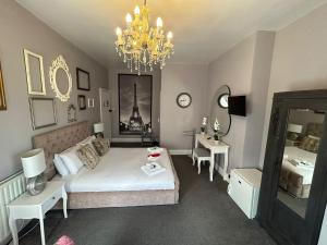 a living room with a bed and a chandelier at The Lyndhurst Guest house in Great Yarmouth