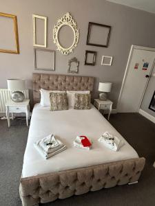 a bedroom with a large bed with two towels on it at The Lyndhurst Guest House in Great Yarmouth