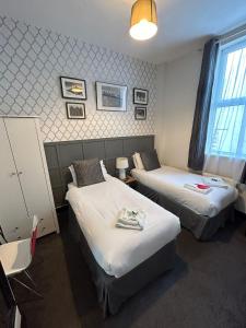 a hotel room with two beds and a window at The Lyndhurst Guest House in Great Yarmouth