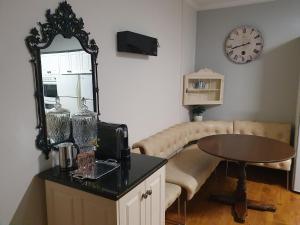 a living room with a mirror and a table and a couch at Grandhome Melbourne Airport & Shops in Melbourne