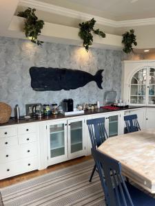 a kitchen with a table and a fish on the wall at The Centerboard Nantucket in Nantucket