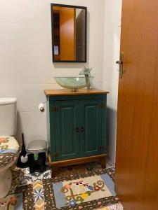 baño con lavabo verde y aseo en Refúgio Amor Demasiado en São Francisco de Paula