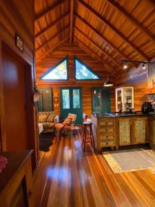 een kamer met een keuken en een woonkamer met houten vloeren bij Refúgio Amor Demasiado in São Francisco de Paula
