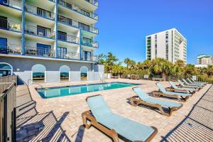 a swimming pool with lounge chairs next to a building at Royal Retreat-Amazing view-King bed-1 bedroom-Full kitchen-Free parking-Self check-in in Myrtle Beach