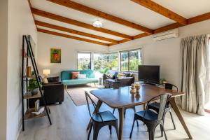 - un salon avec une table et des chaises dans l'établissement Onetangi Beach Retreat - Waiheke Holiday Home, à Onetangi