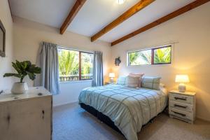 1 dormitorio con cama y ventana en Onetangi Beach Retreat - Waiheke Holiday Home, en Onetangi