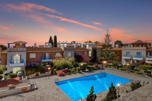 een groot zwembad in een tuin met gebouwen bij Antonia's Palace Rooftop Jacuzzi Stunning View in Paphos City