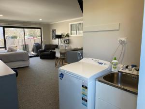 uma cozinha com um lavatório e uma sala de estar em Location Location Location em Cromwell