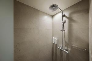 a shower with a shower head in a bathroom at Fairfield by Marriott Fukuoka Ukiha in Ukiha