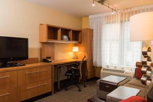 a room with a desk with a computer and a television at TownePlace Suites by Marriott Erie in Erie