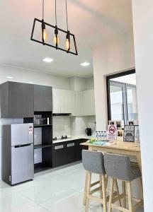 a kitchen with a counter with chairs and a refrigerator at Sun Seaview Country Garden Danga Bay Luxury Condominium in Johor Bahru
