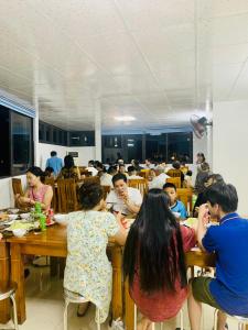 a group of people sitting at tables in a restaurant at Hồng Anh 2 Hotel in Ha Long +21 photos