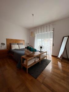a bedroom with a bed and a table and a window at Apartamento do Atlântico in Ponta Delgada